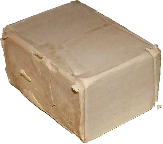 Un cubo de levadura fresca, beige claro y desmoronado en las orillas