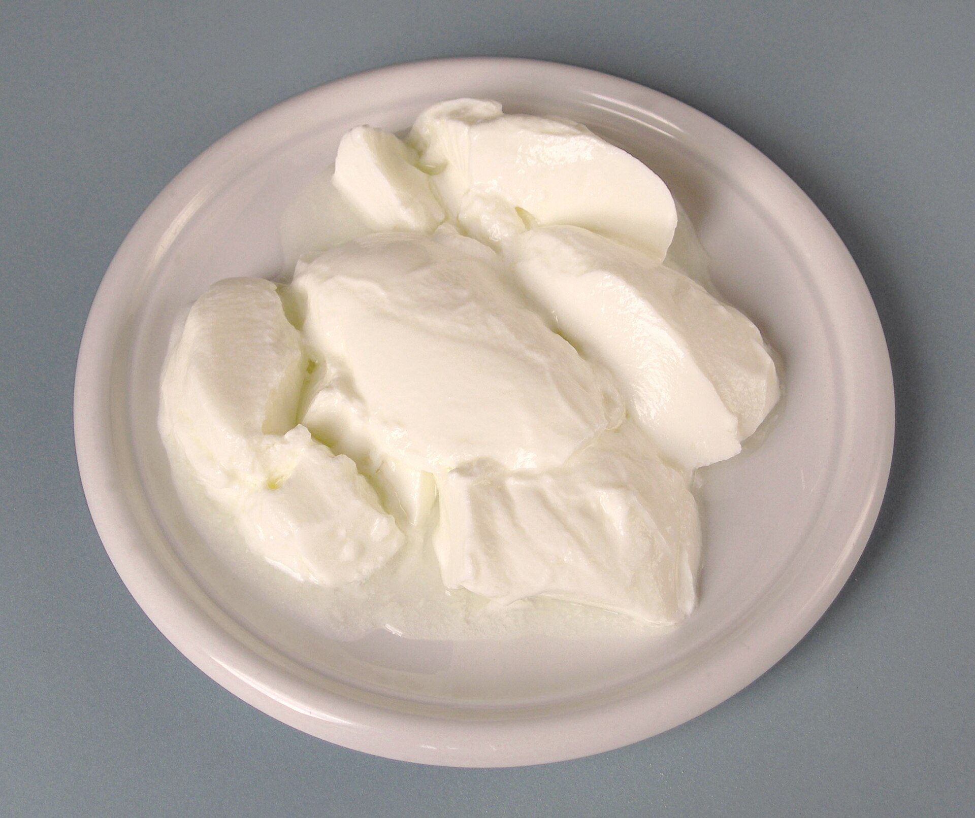 Yogur natural cuajado en un plato blanco, sin fruta y sin azúcar