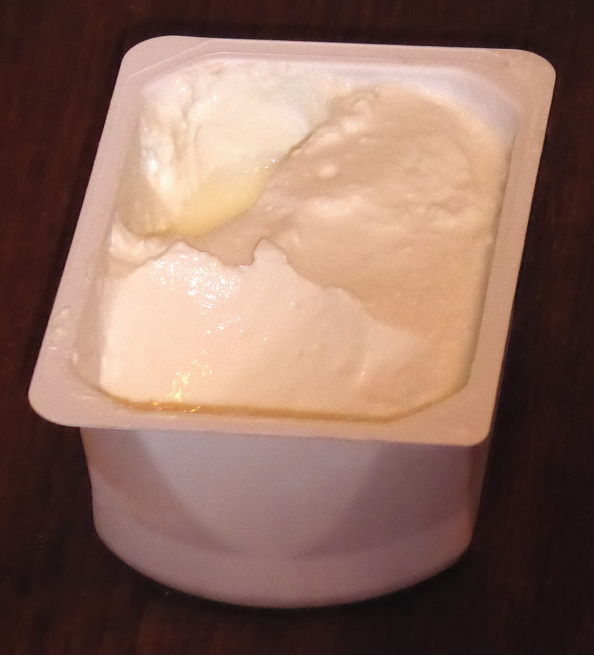 Un bote abierto de quark, blanco y granuloso