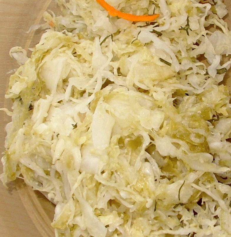 Chucrut crudo de cerca, col blanca rallada fina en un traste de madera