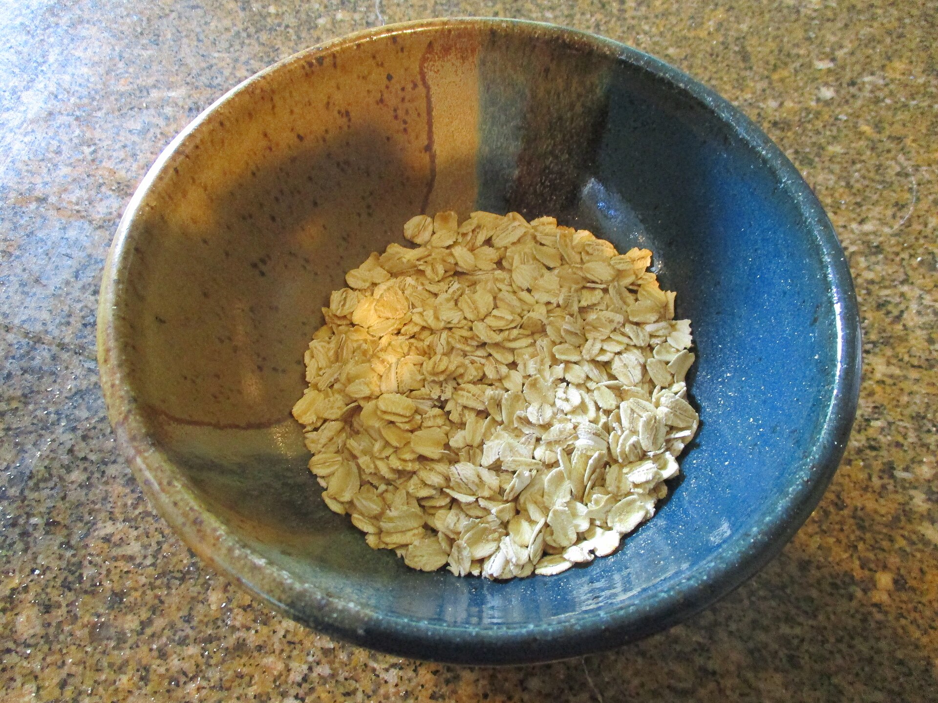 Hojuelas de avena en un tazón, aplanadas y de color claro