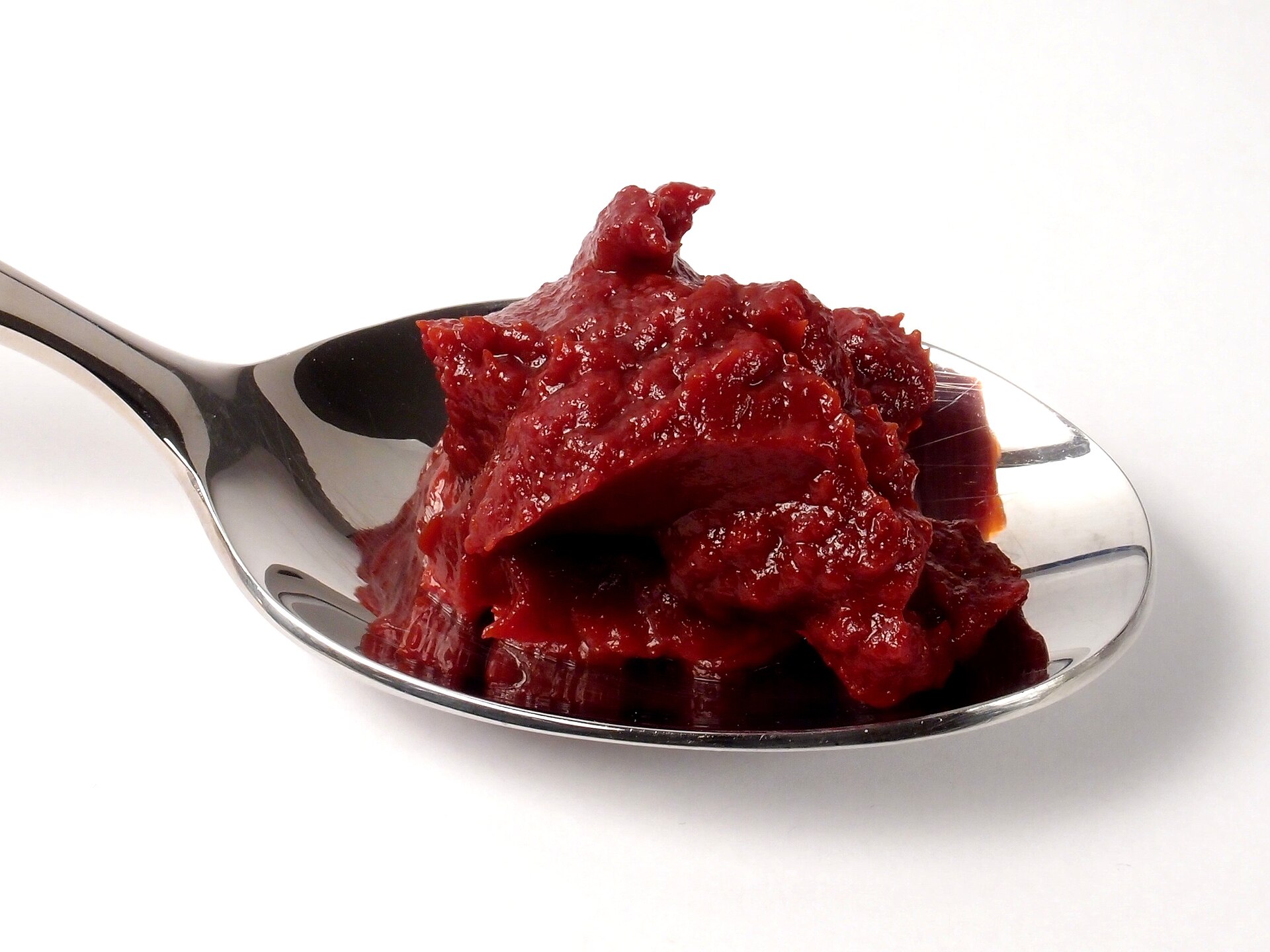 Una cucharada de concentrado de tomate espeso y rojo oscuro, tan firme que mantiene la forma